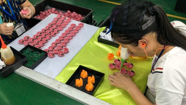 The chips for Beasts of Balance stackable game pieces being inserted during manufacturing